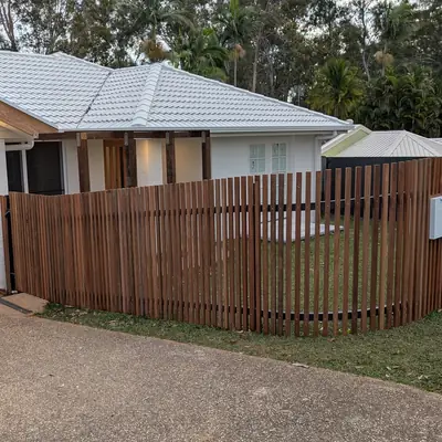 Timber slat fence along a front lawn and driveway