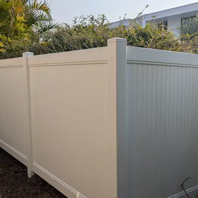 Cream PVC privacy fence corner with stepping stones and garden bed