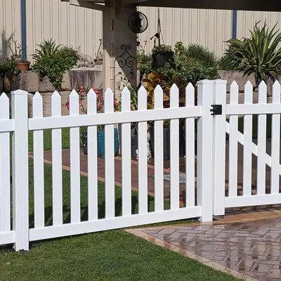 White PVC picket fence and matching gate in a front garden
