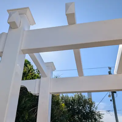 White PVC pergola with decorative beam ends