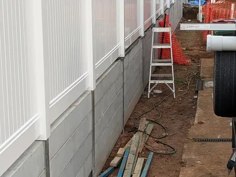 Tall white fence panels installed along a side boundary