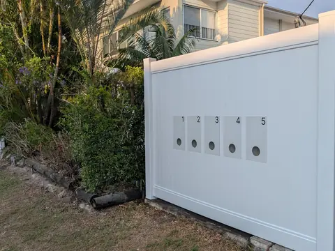 White solid panel fence with round access openings