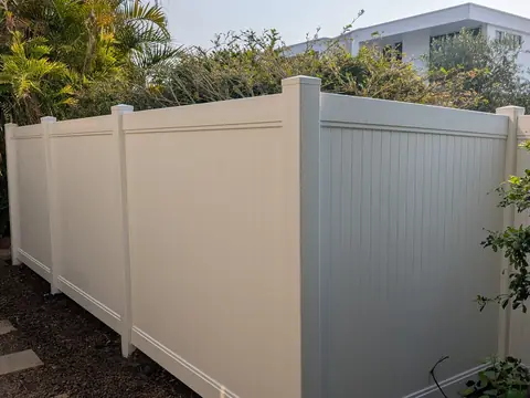 Cream PVC privacy fence around a garden corner