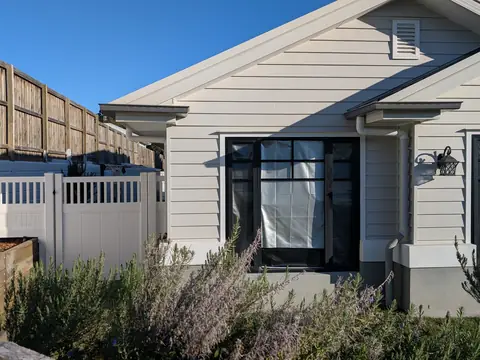 White PVC fence with slatted top section in front of a weatherboard home