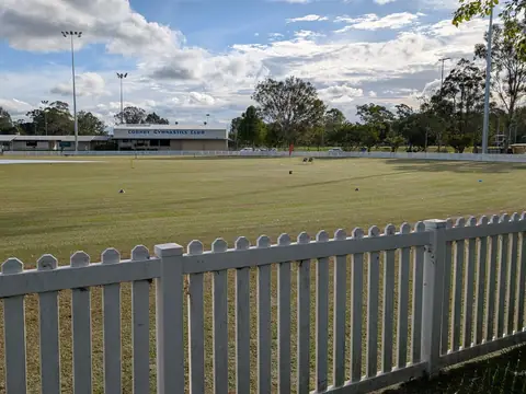 White PVC picket fence along the edge of a sports field